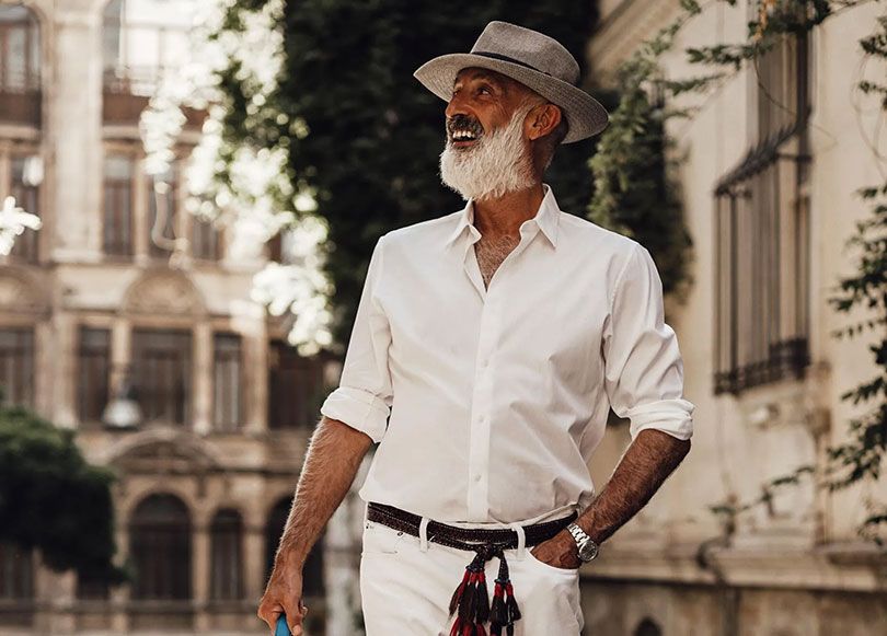 Mann mit Hut spaziert auf einer Straße
